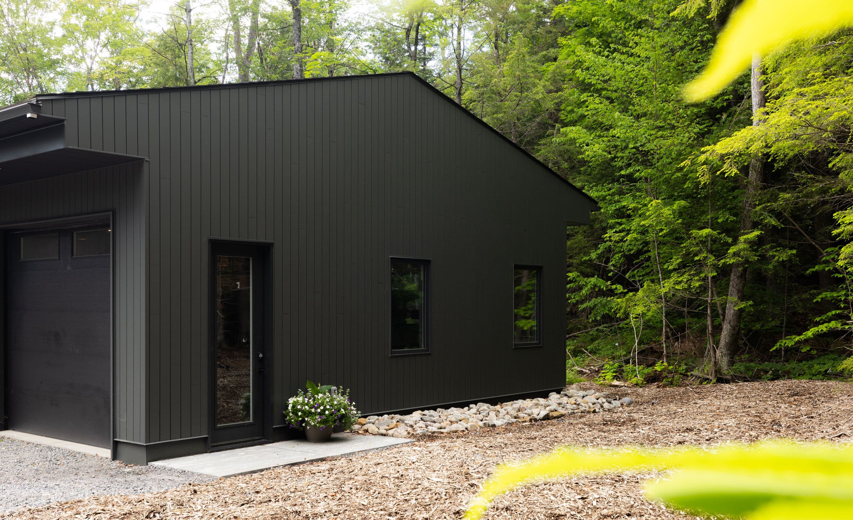 A modern black-sided home tucked into the forest in Muskoka.