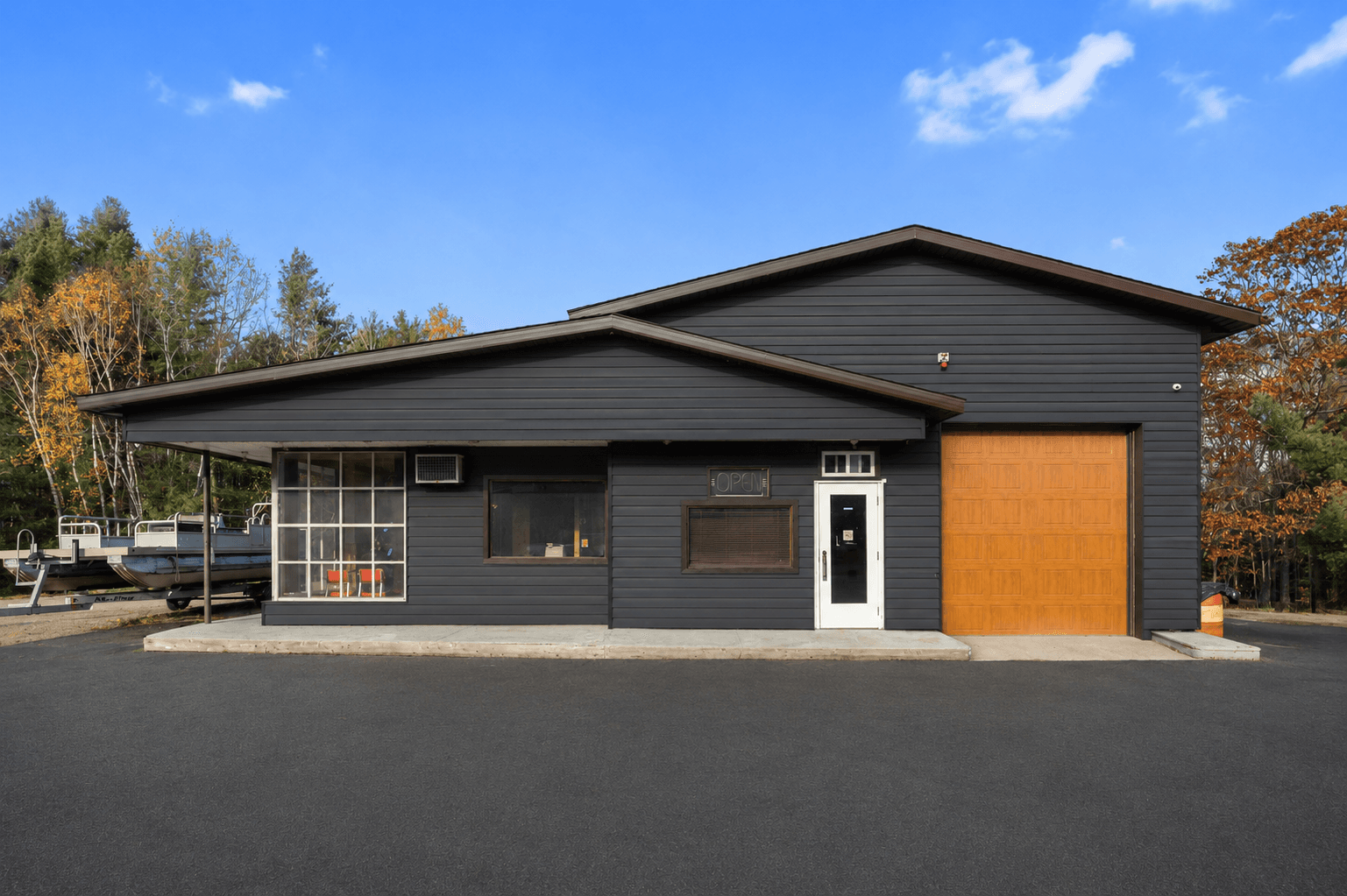 A commercial building with dark siding and an oversized garage door in the Parry Sound area.